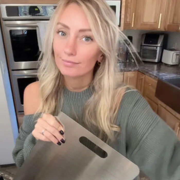 Katori customer Emily holding the titanium board in her kitchen