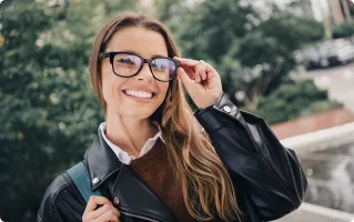 Smiling woman adjusting her smart glasses outdoors