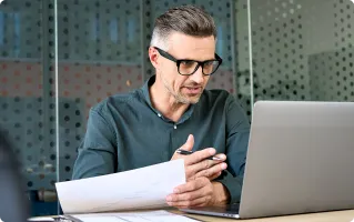 Professional working at a laptop wearing smart glasses